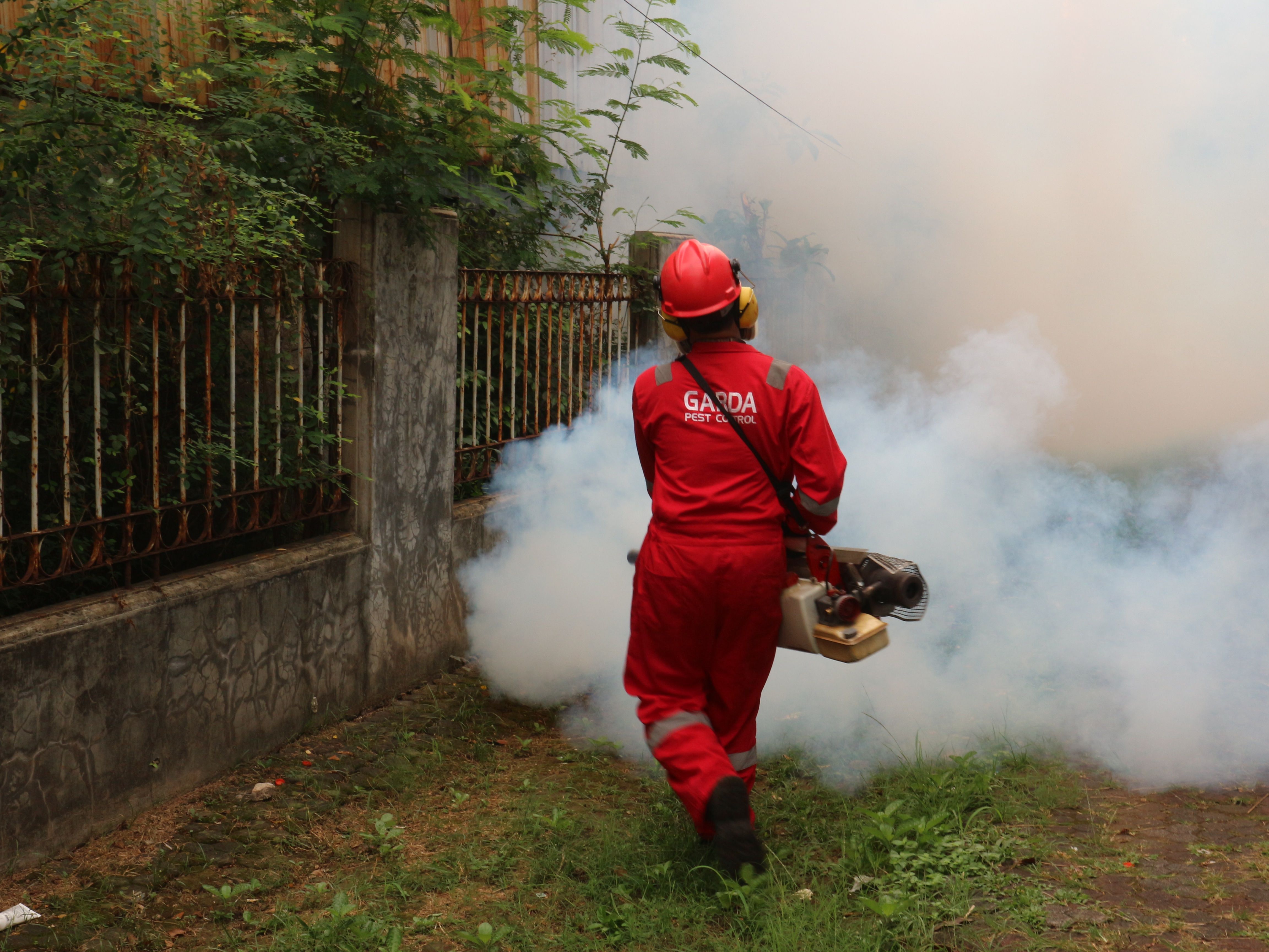 A pest control technician in protective equipment inspecting a UK property